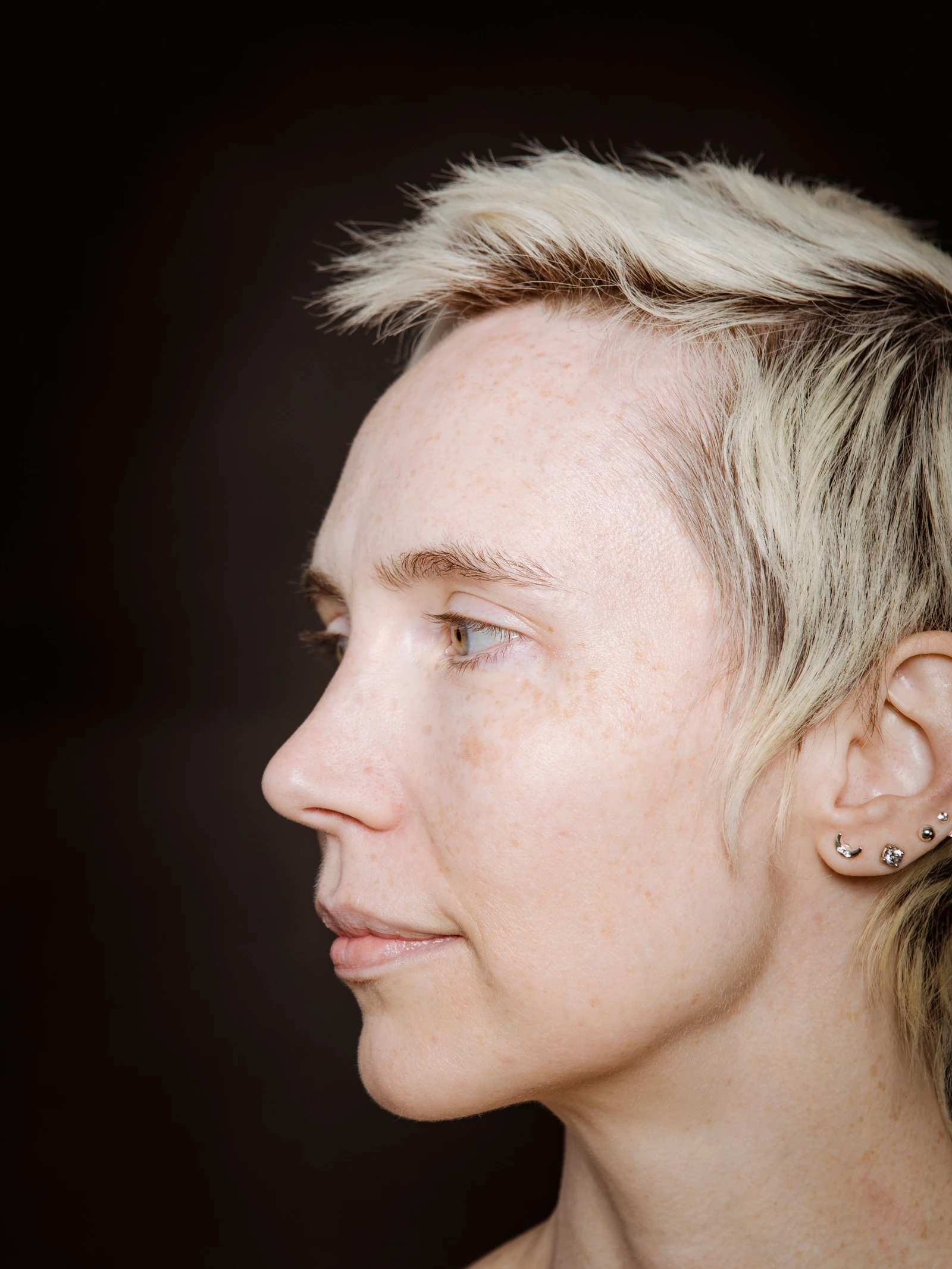 Side profile in soft light, showing natural facial contours.