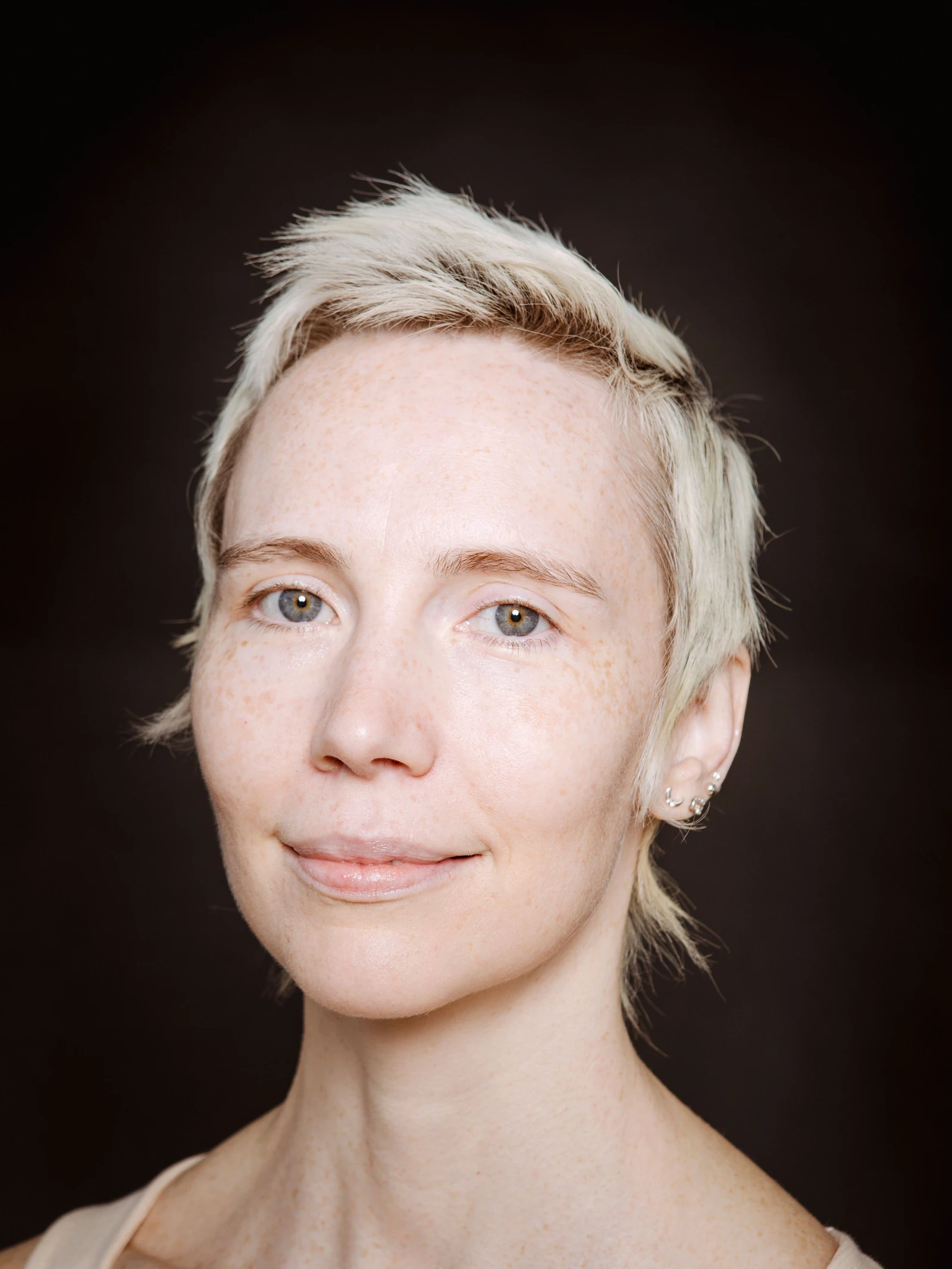 Portrait with a gentle smile and visible freckles.