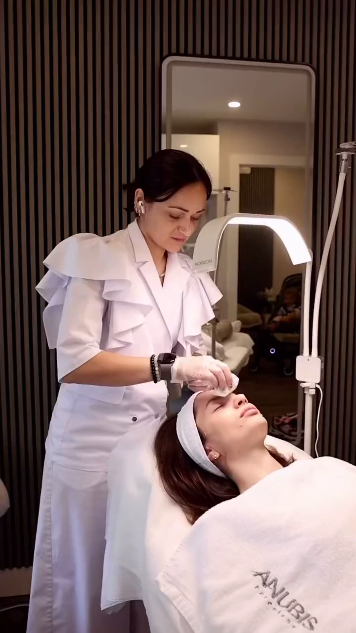 Yuliia preparing a client’s forehead with a cotton pad at BE SPACE.